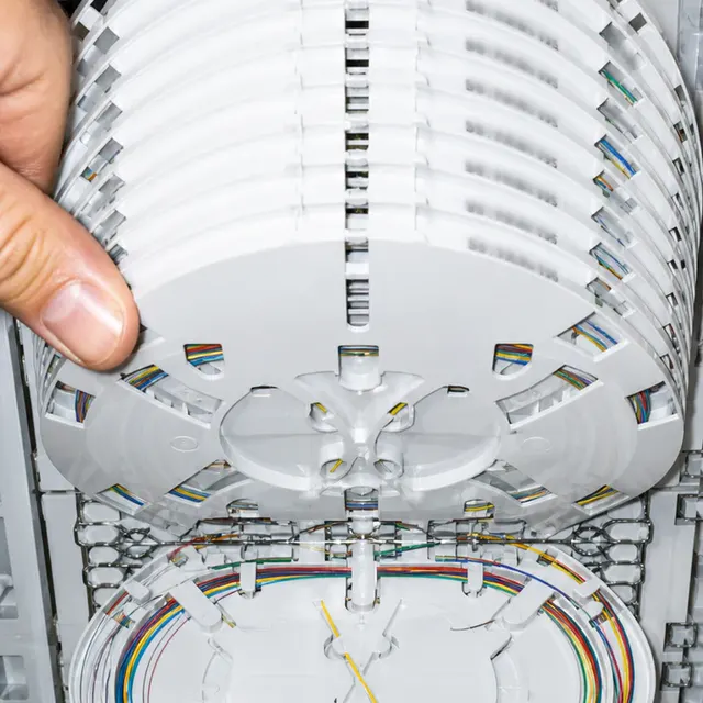 Technicien TIMFibre manipulant les cassettes de soudure d'un boîtier fibre optique